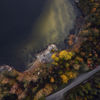 An aerial shot of a road running through a forest on the Swedish west coast