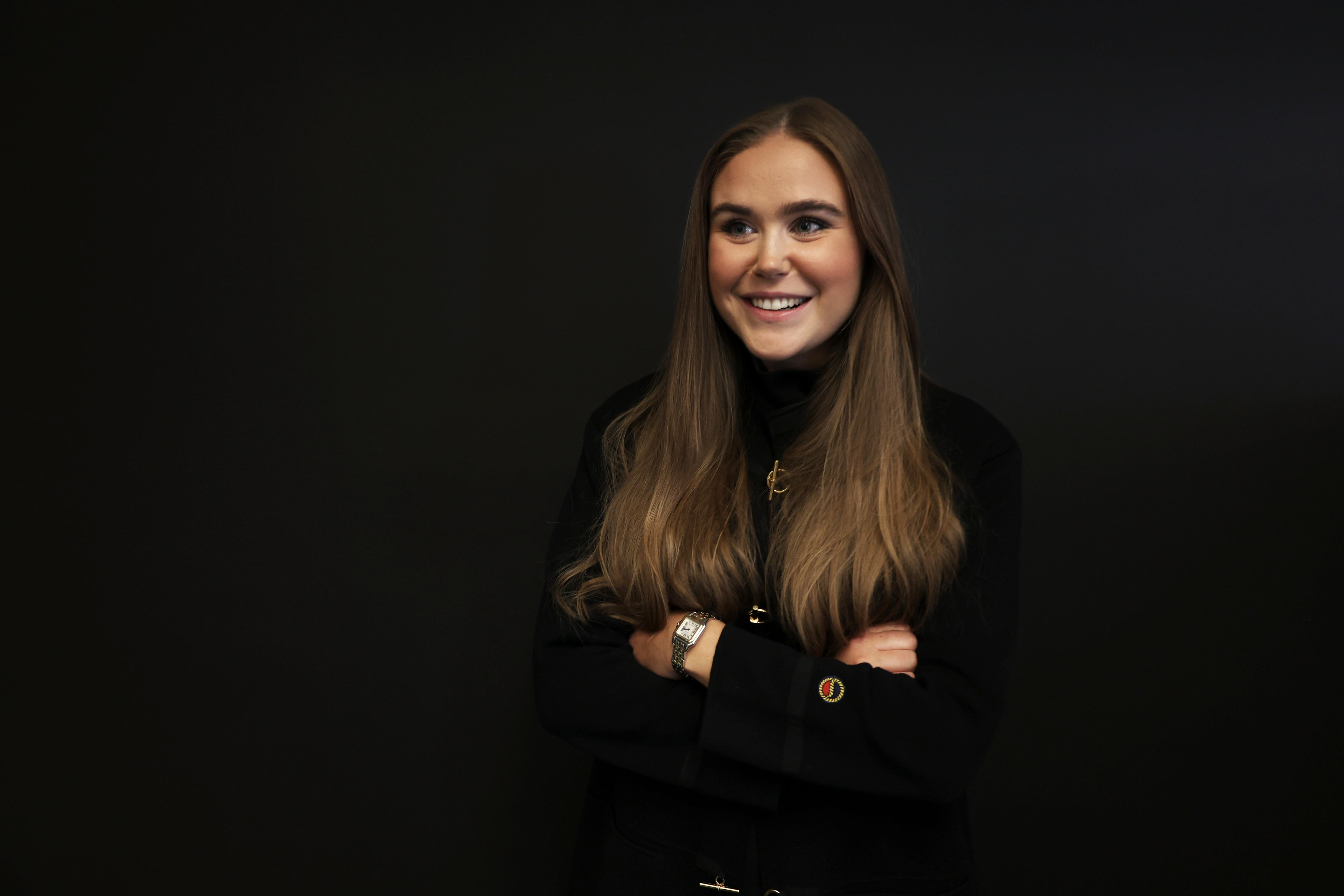 Woman smiling in front of a black background